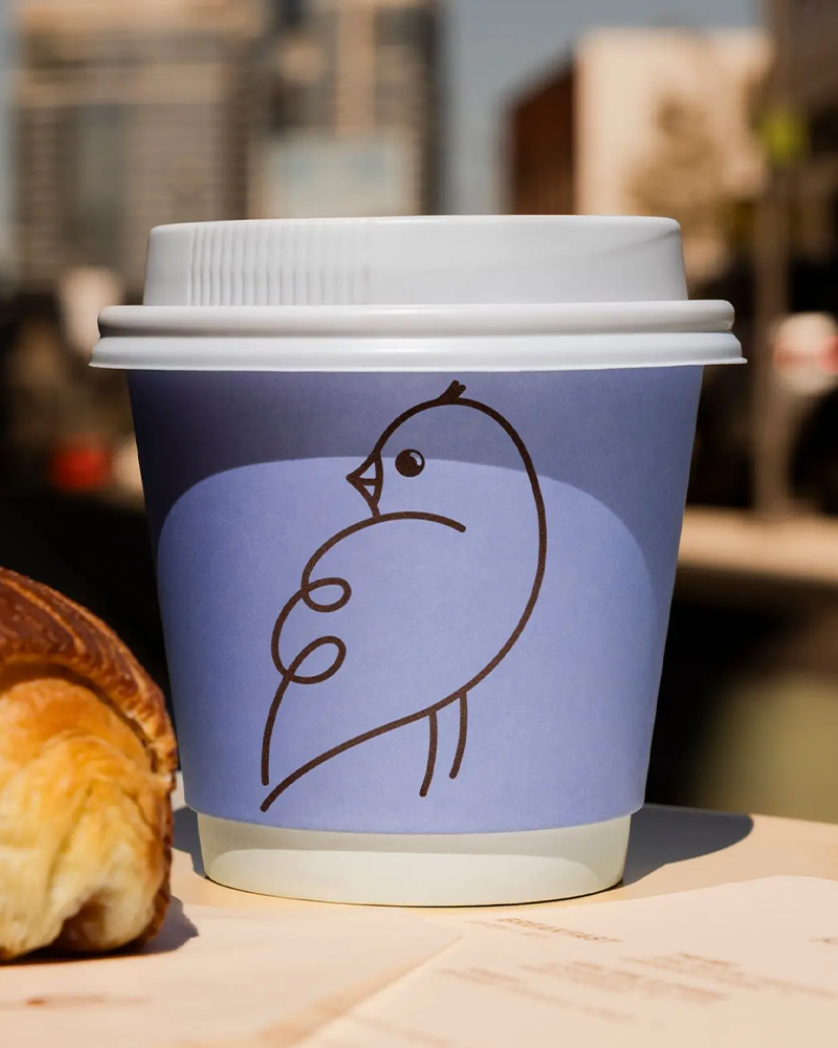 Birdee logo on purple disposable coffee cup