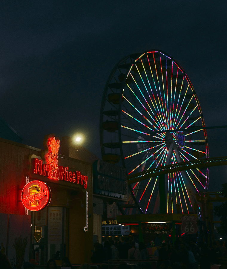 Image of Santa Monica Pier at night with neon restaurant sign and ferris wheel