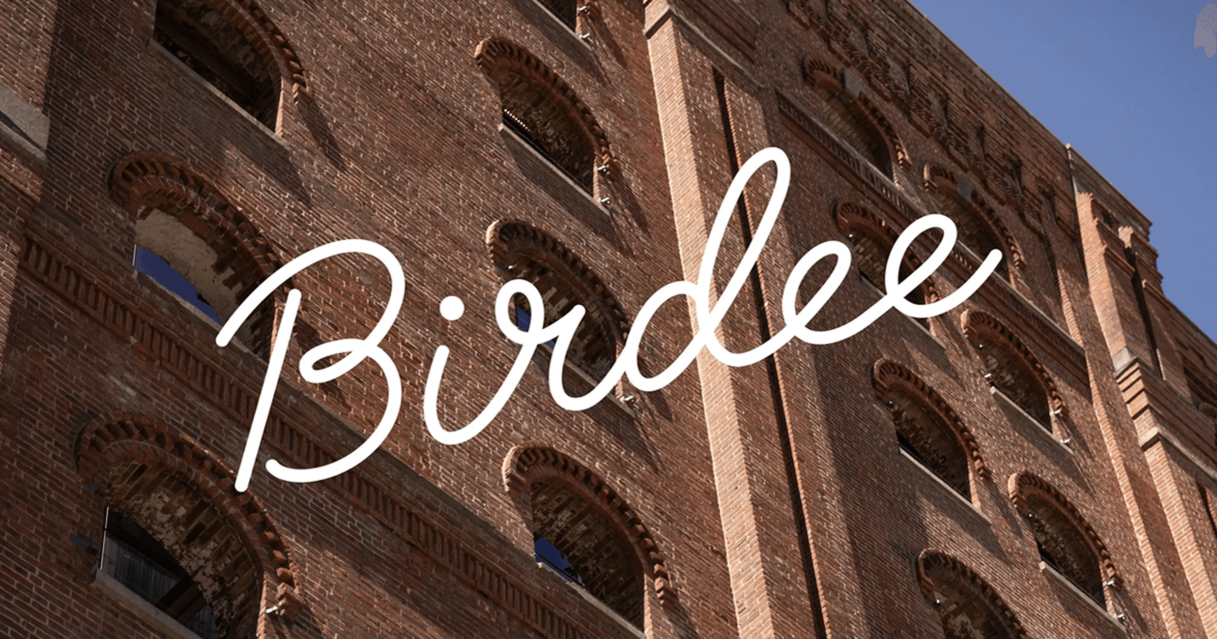 Birdee logo superimposed over city apartment building