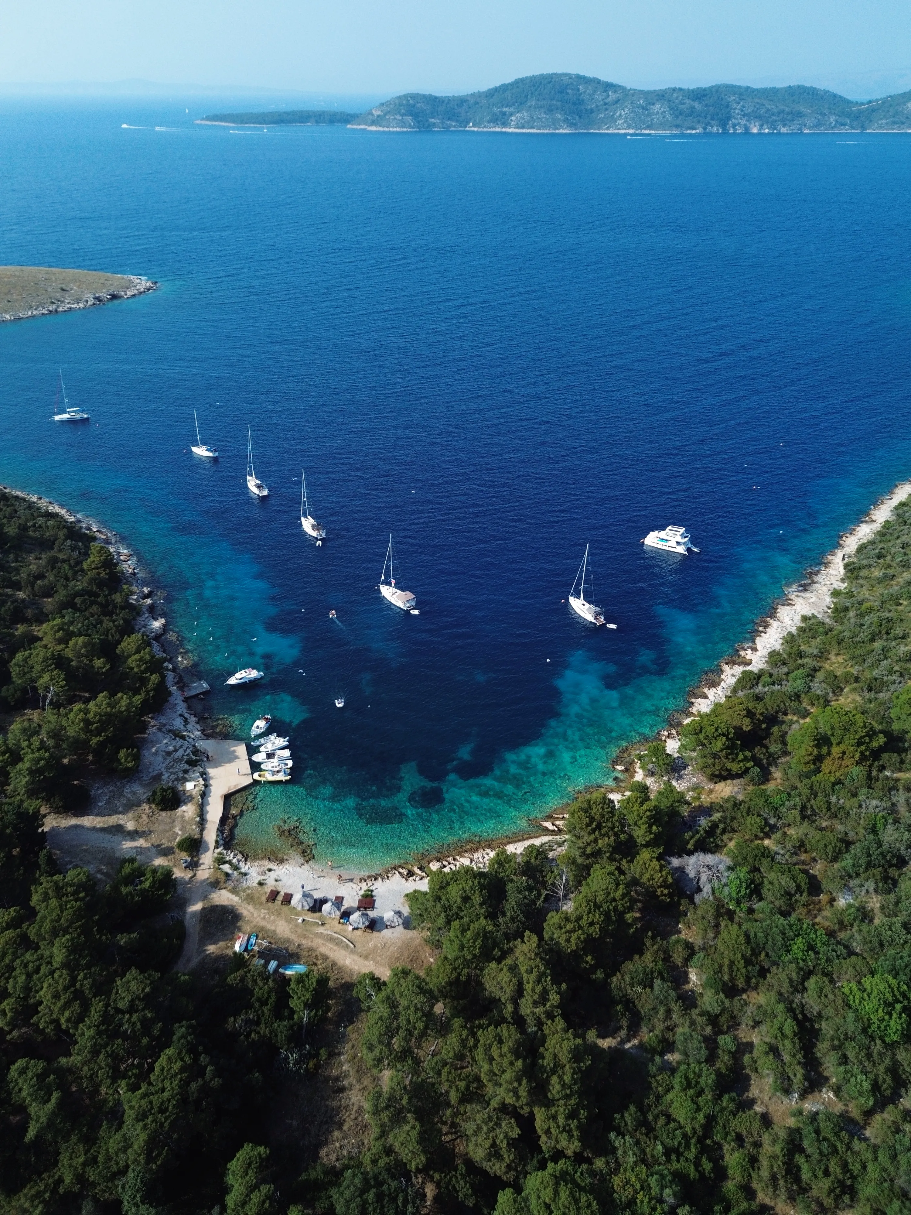 Veleros y catamaranes fondeados en una bahía cerca de Hvar