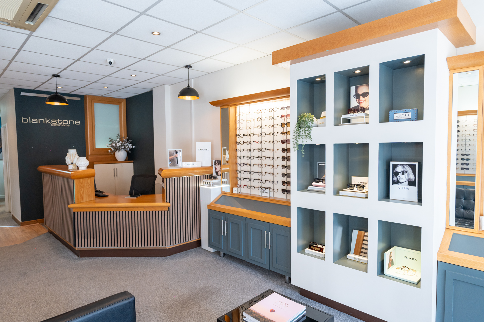 Modern eyewear store interior with wooden accents, display shelves, and reception counter