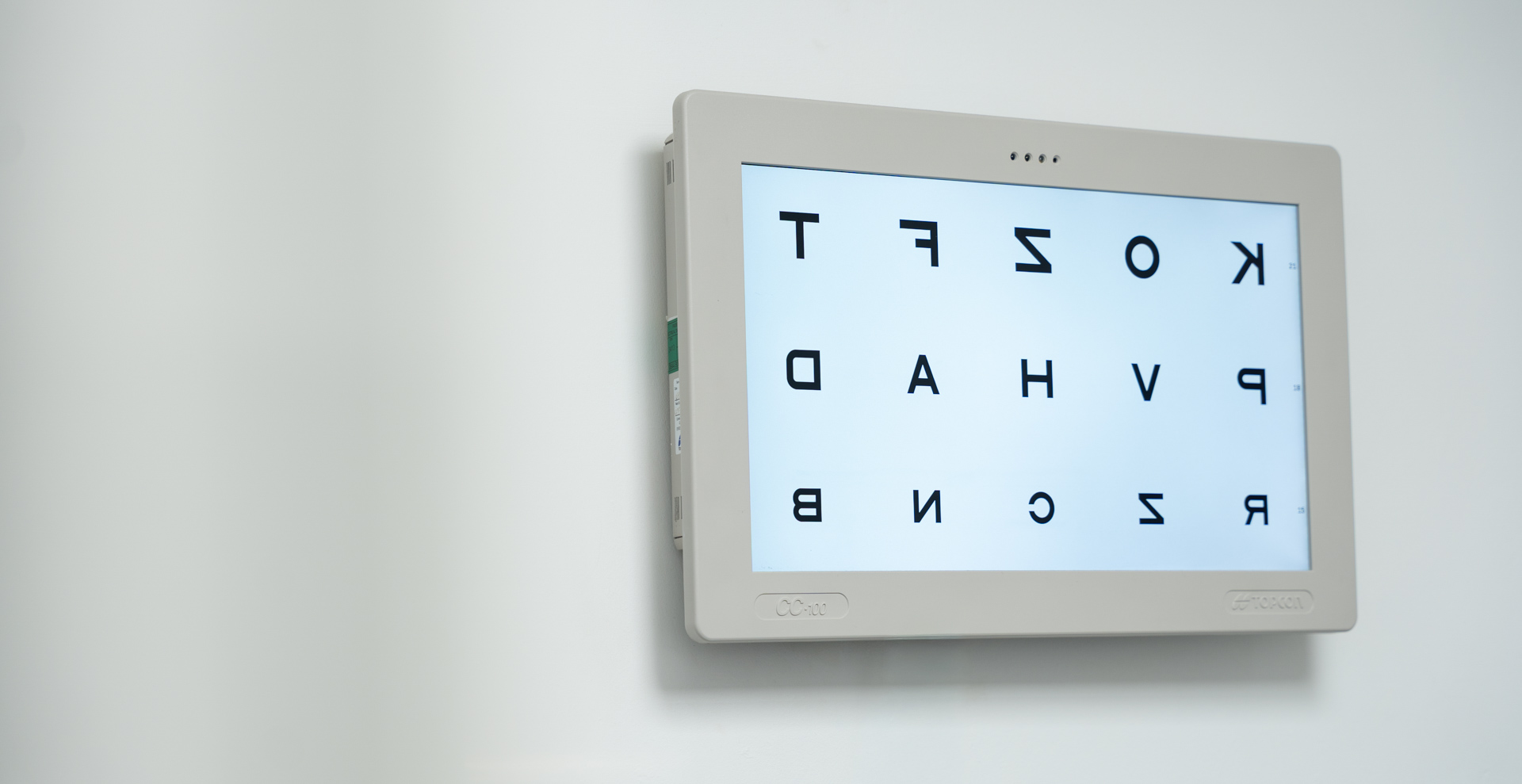 Eye exam chart displayed on white tablet mounted on wall
