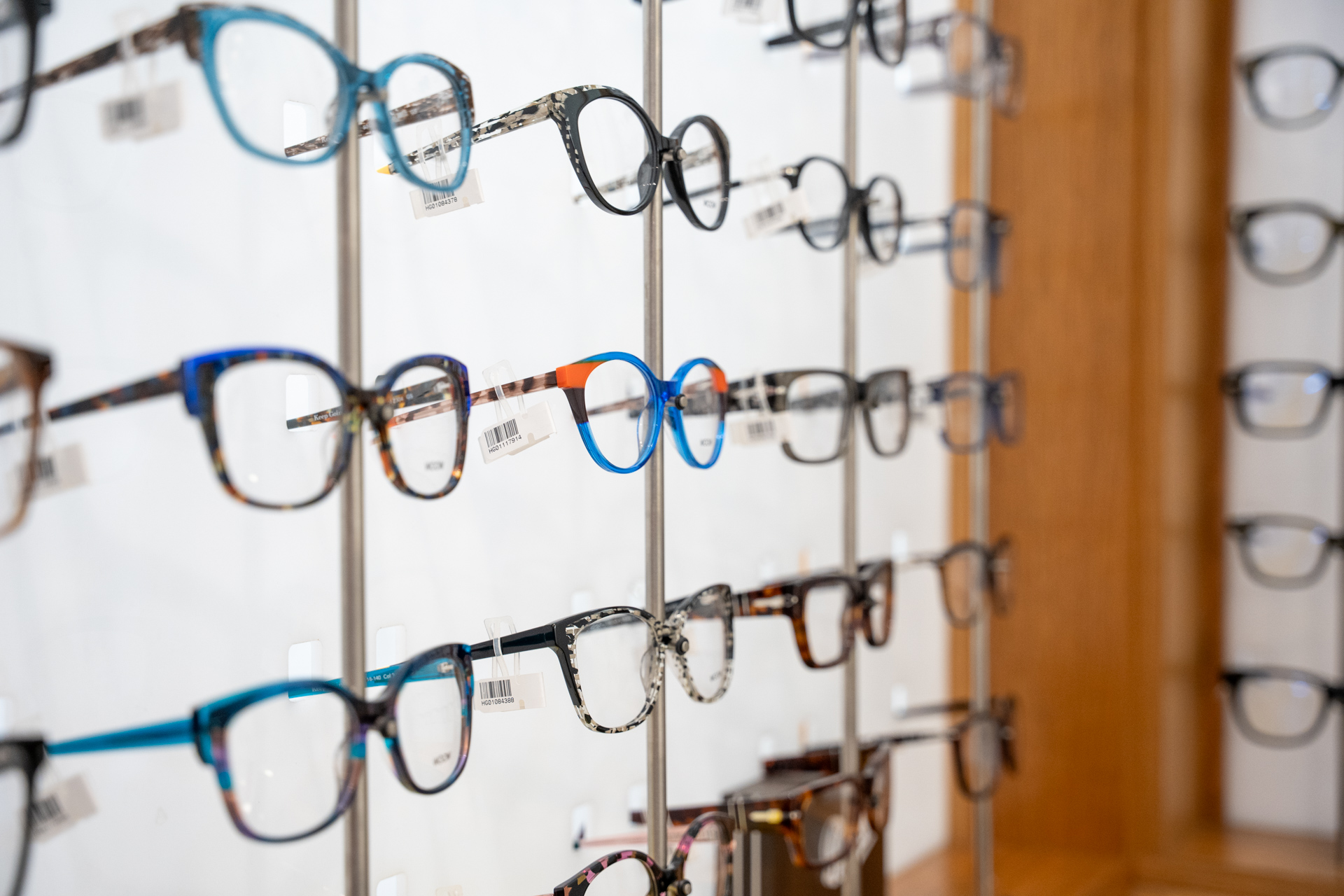 Display of eyeglasses with various frame styles and colors in optical shop