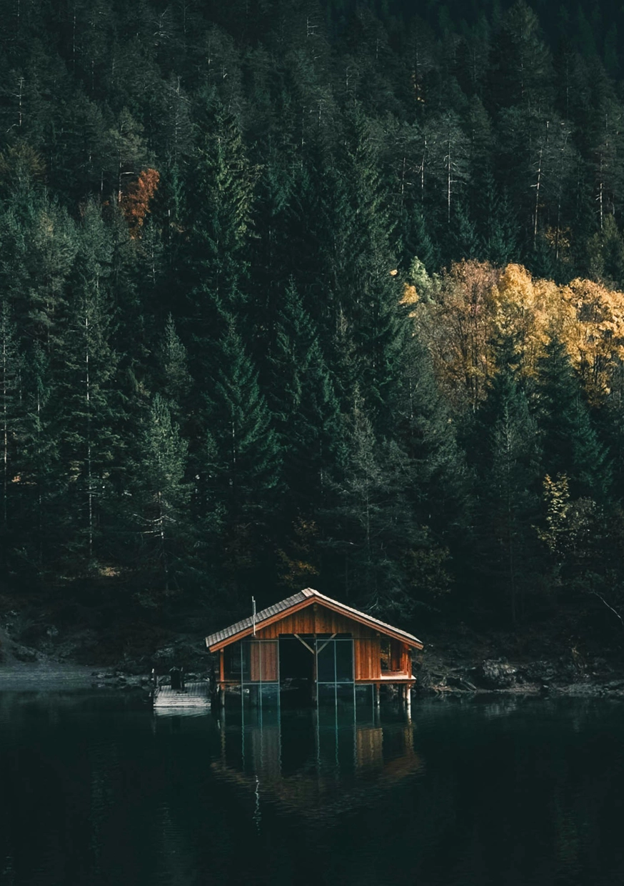 Cabane en bois au bord d’un lac entouré de forêts de conifères au Québec. Paysage nature et sauvage lors d’un road trip au Canada avec Beaux Périples