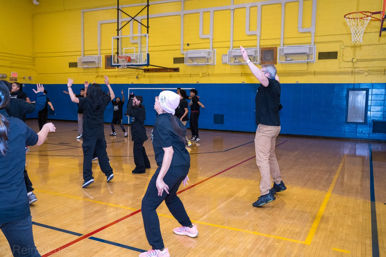 Students and instructor dancing together in school gymnasium