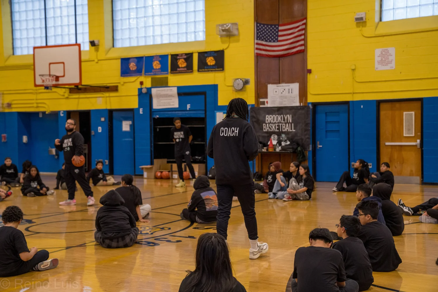 Brooklyn Basketball coaches leading a gym session with seated students