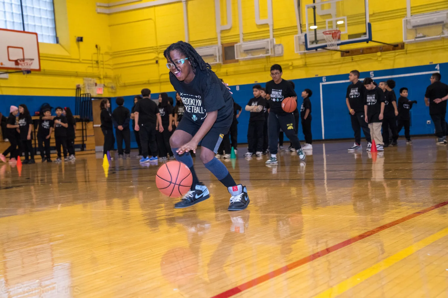 Student dribbling basketball during Brooklyn Basketball gym program