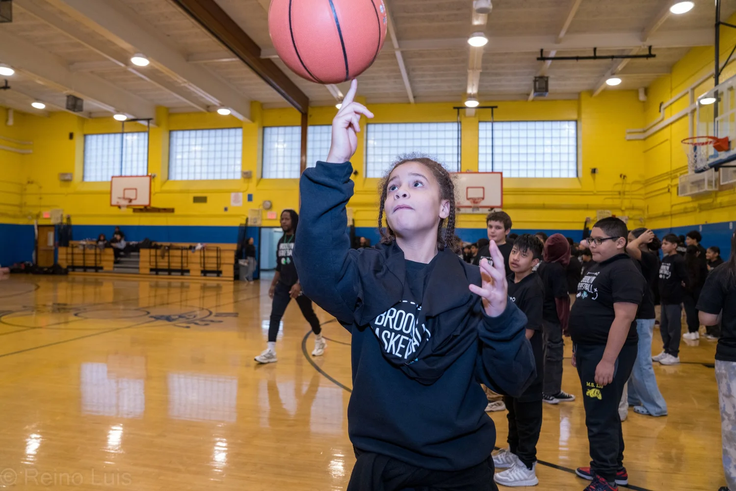 Student spinning basketball on finger during gym class activity