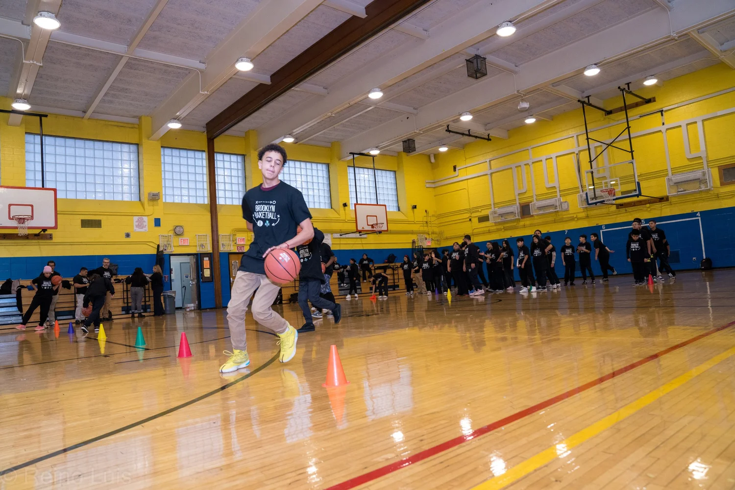Student dribbling basketball through cones during gym class drill