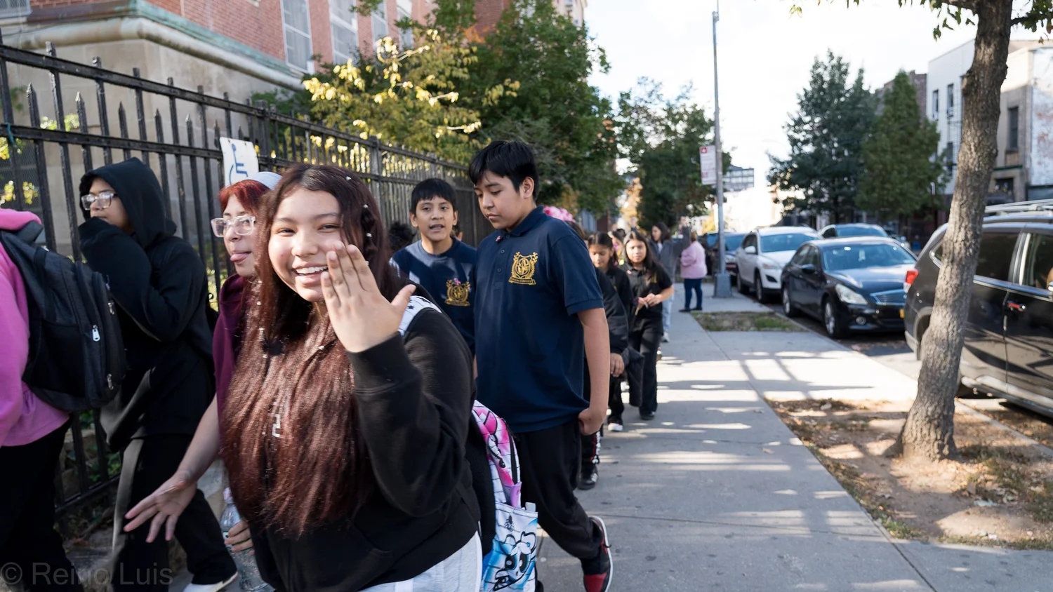 Students walking along sidewalk outside school building