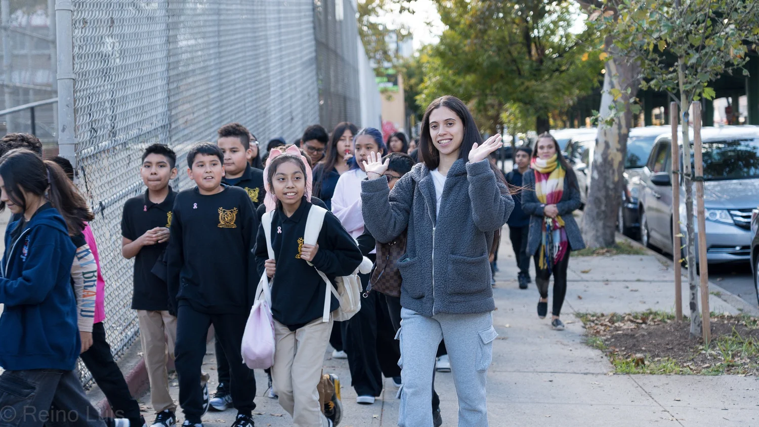 Students and teacher walking together along a school sidewalk
