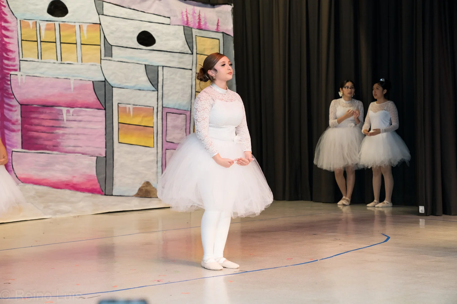 Student performs ballet in white tutu during school stage production
