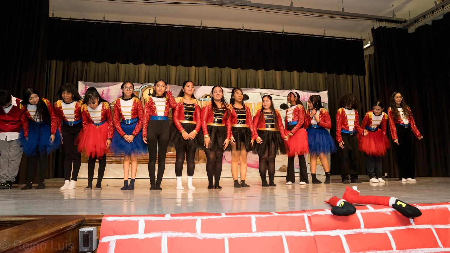 Students in nutcracker costumes performing on school stage