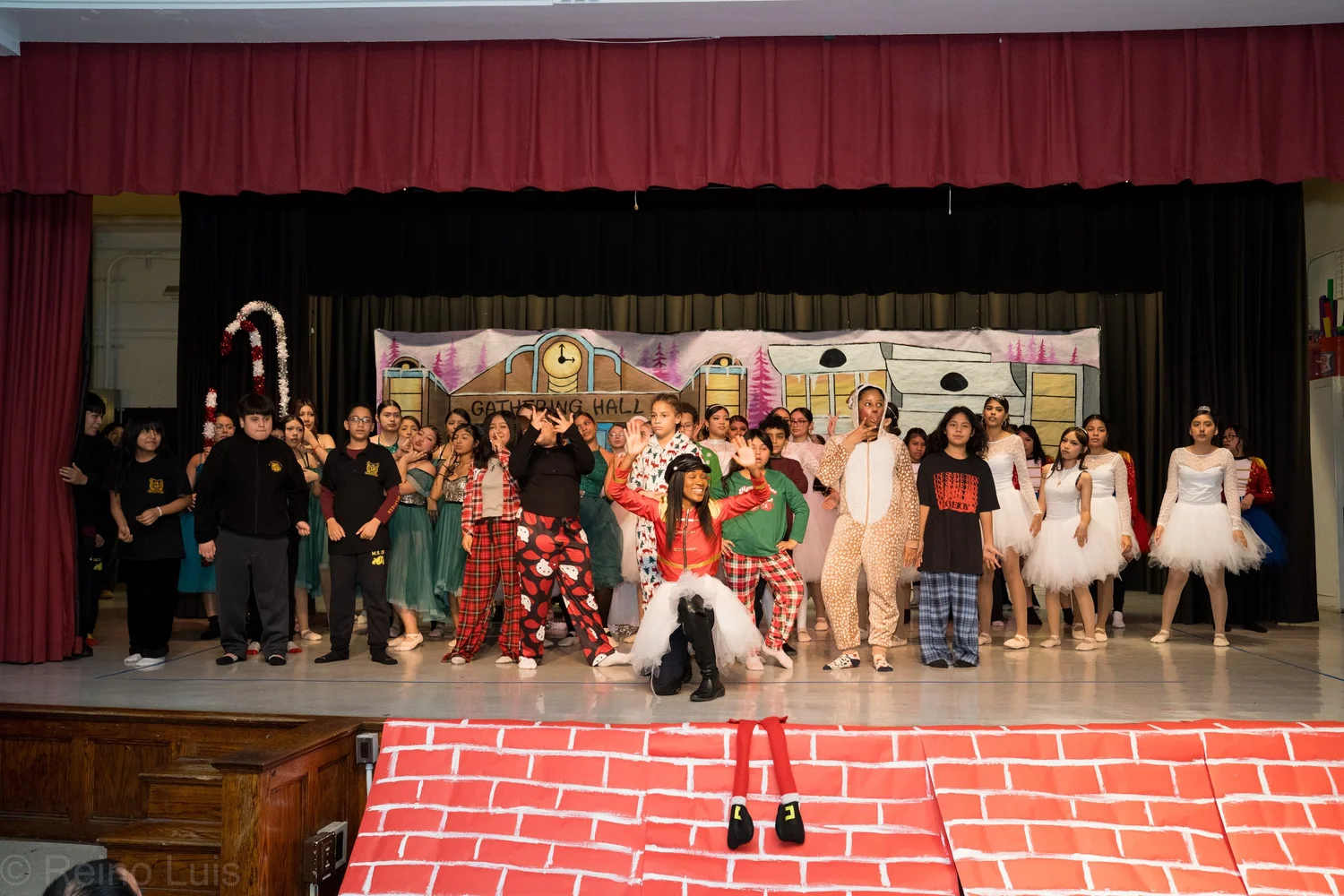 Students performing a holiday stage production in costumes on school stage