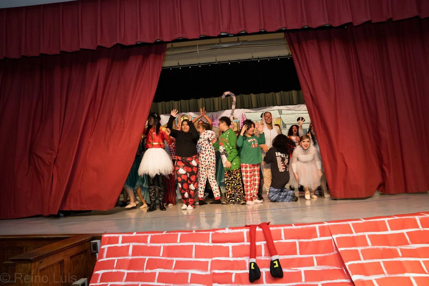 Students perform a holiday stage show in festive costumes