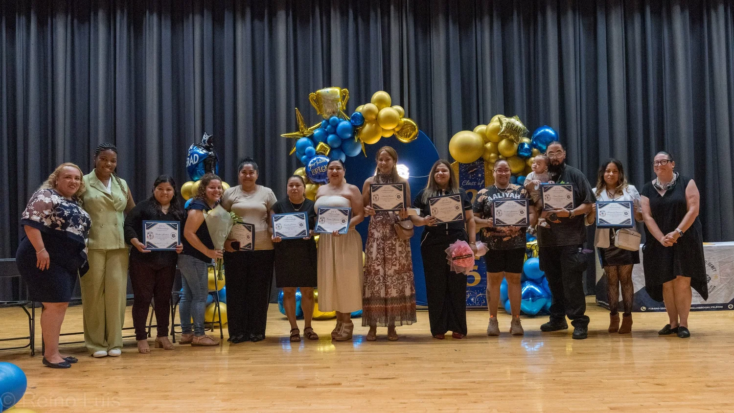 Graduates holding certificates on stage at a school ceremony