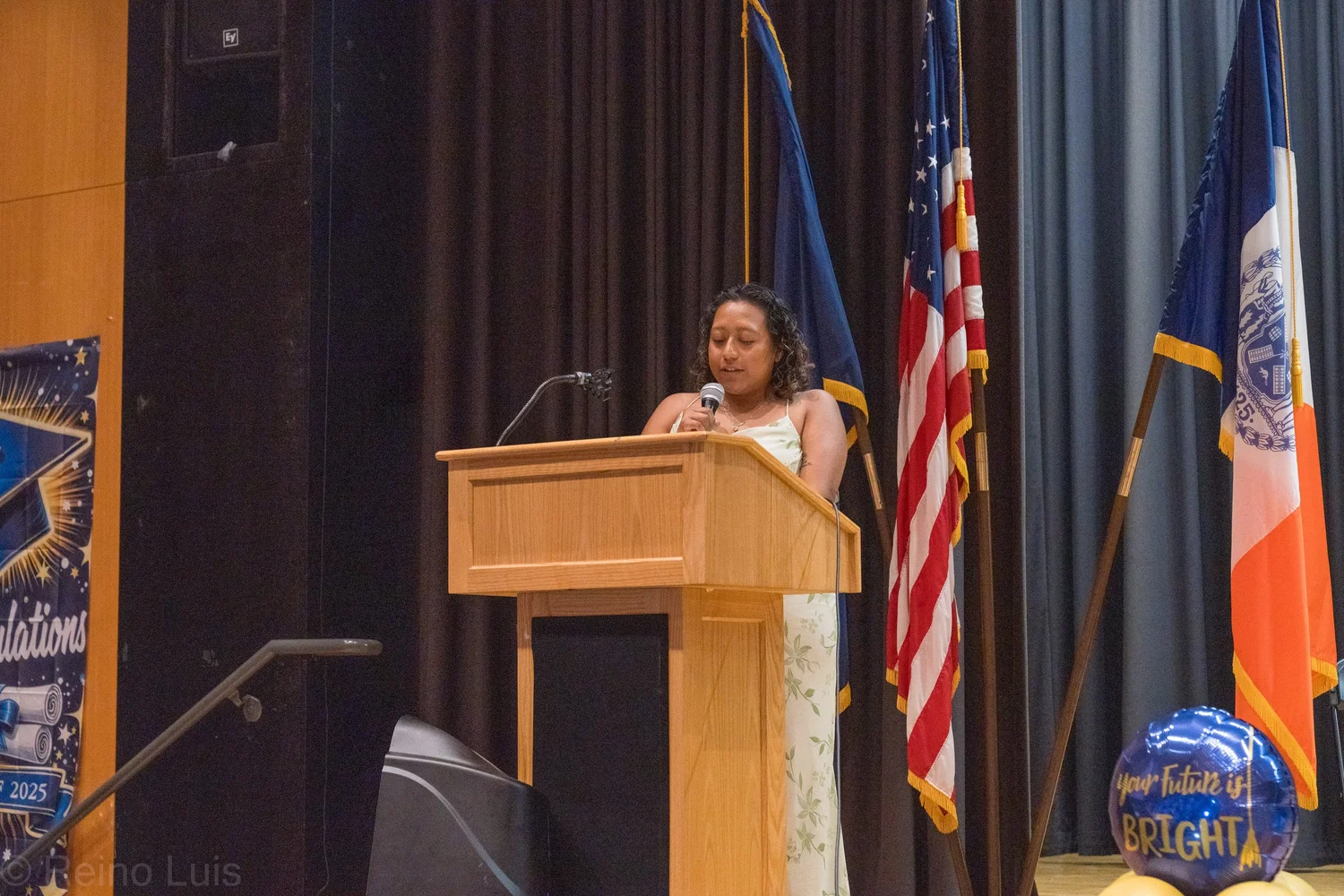 Speaker addresses podium at MS 136 graduation ceremony 2025
