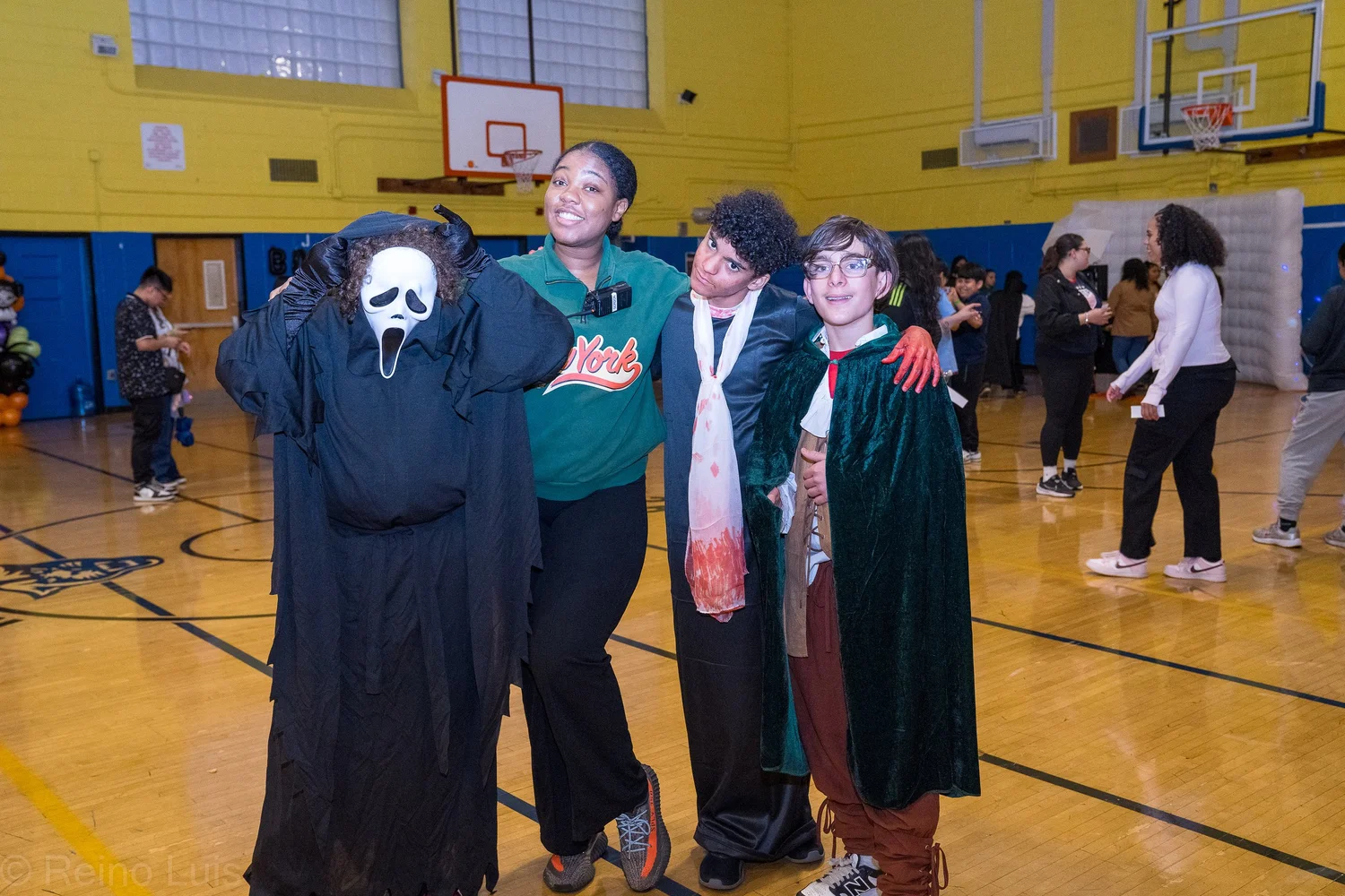 Students pose in Halloween costumes in school gymnasium