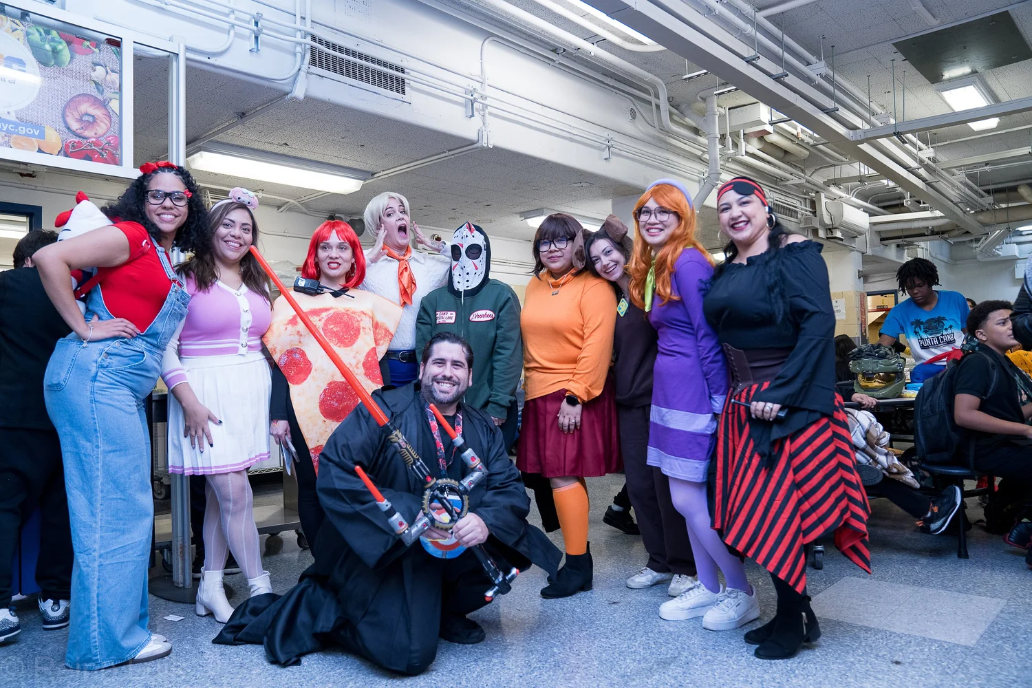 School staff posing in Halloween costumes inside the building