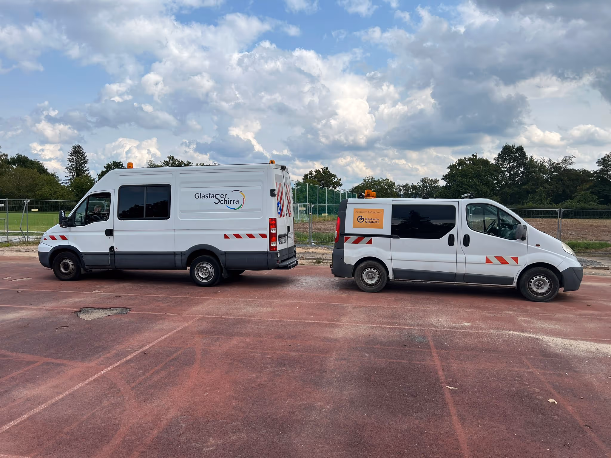 Zwei Fahrzeuge von Glasfaser Schirra auf einem Parkplatz