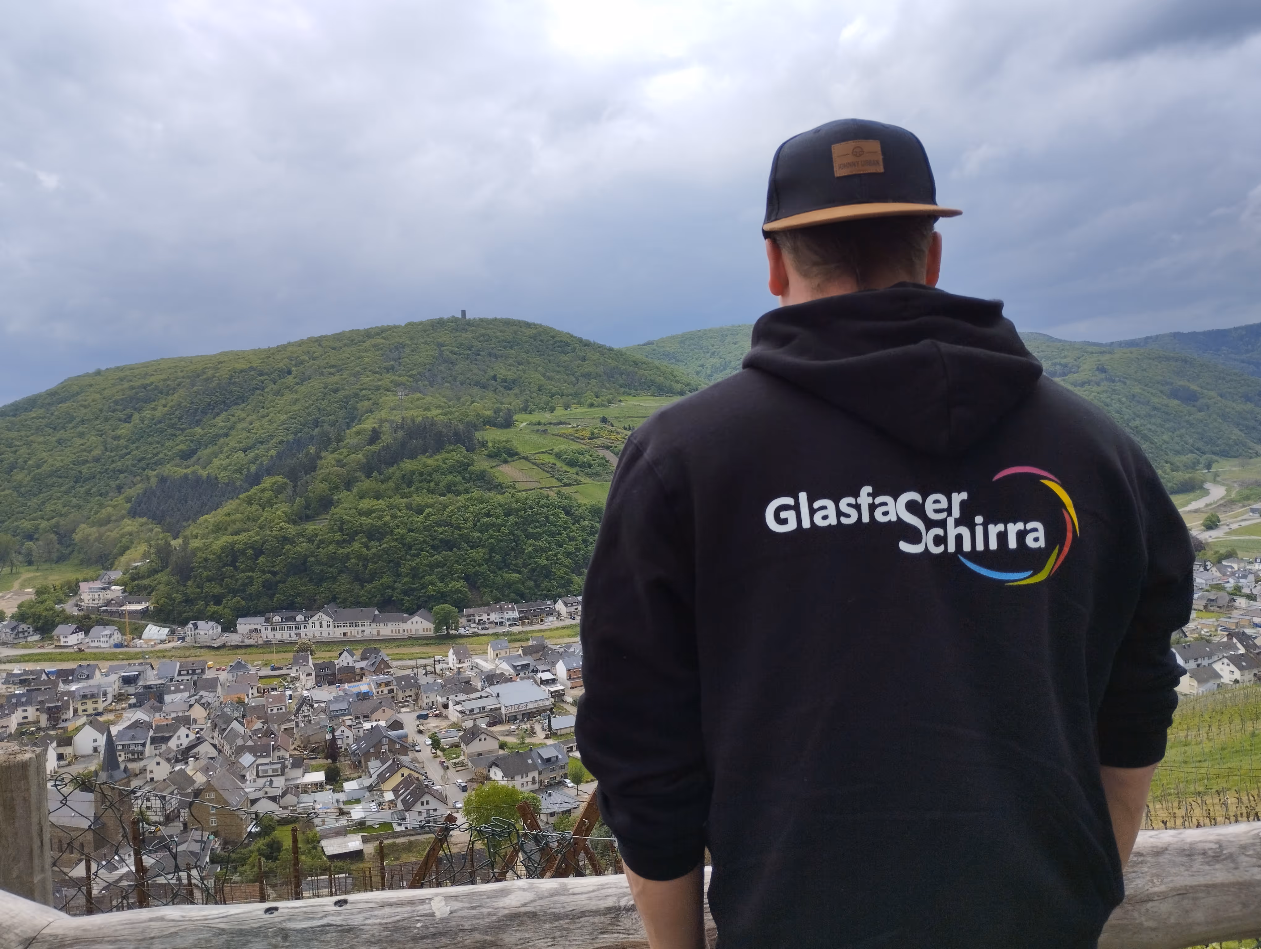 Marcel Schirra mit einem Pullover von hinten fotografiert mit einem Ausblick auf Landschaft