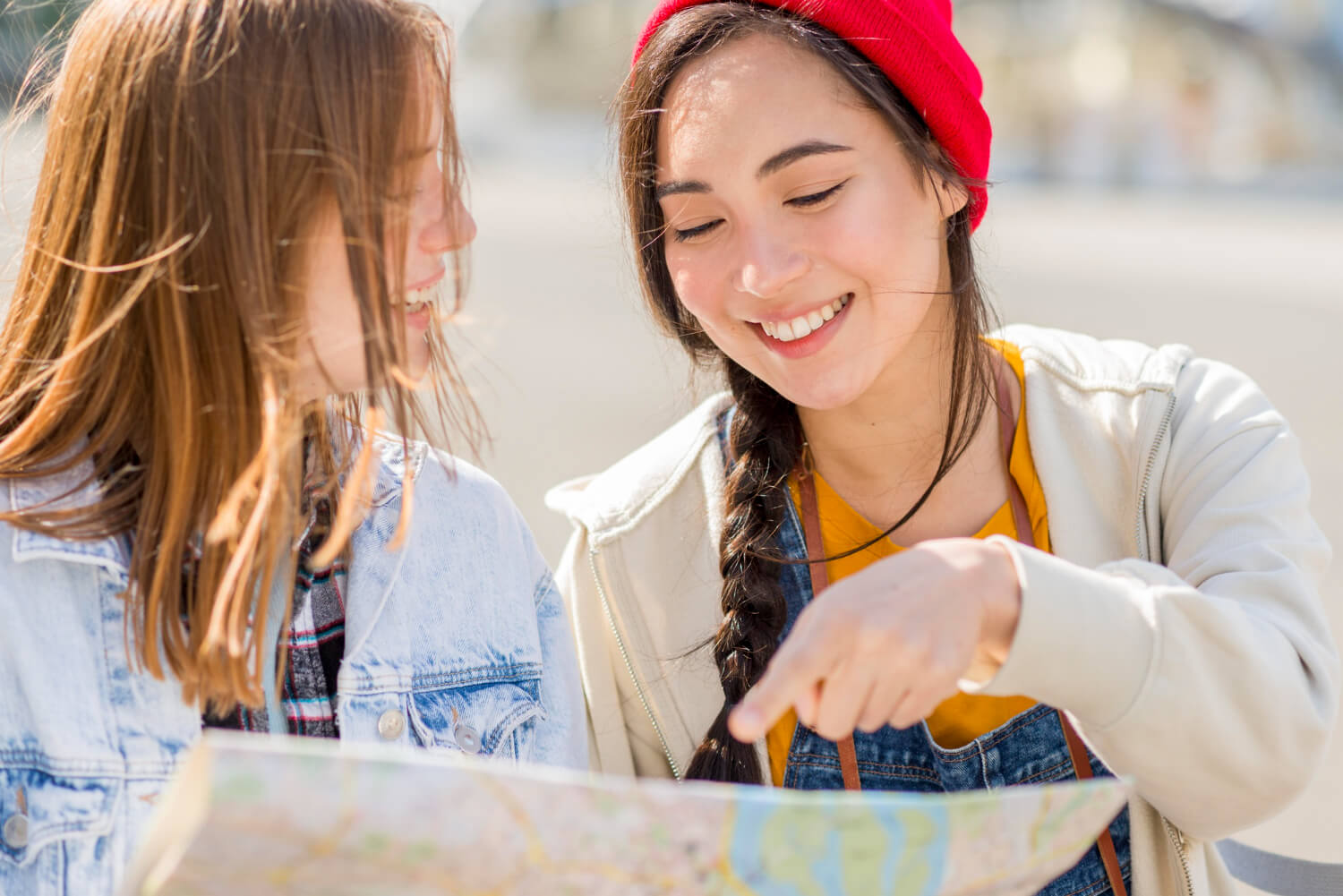 Dos personas observan un mapa al aire libre mientras conversan y señalan una ubicación.
