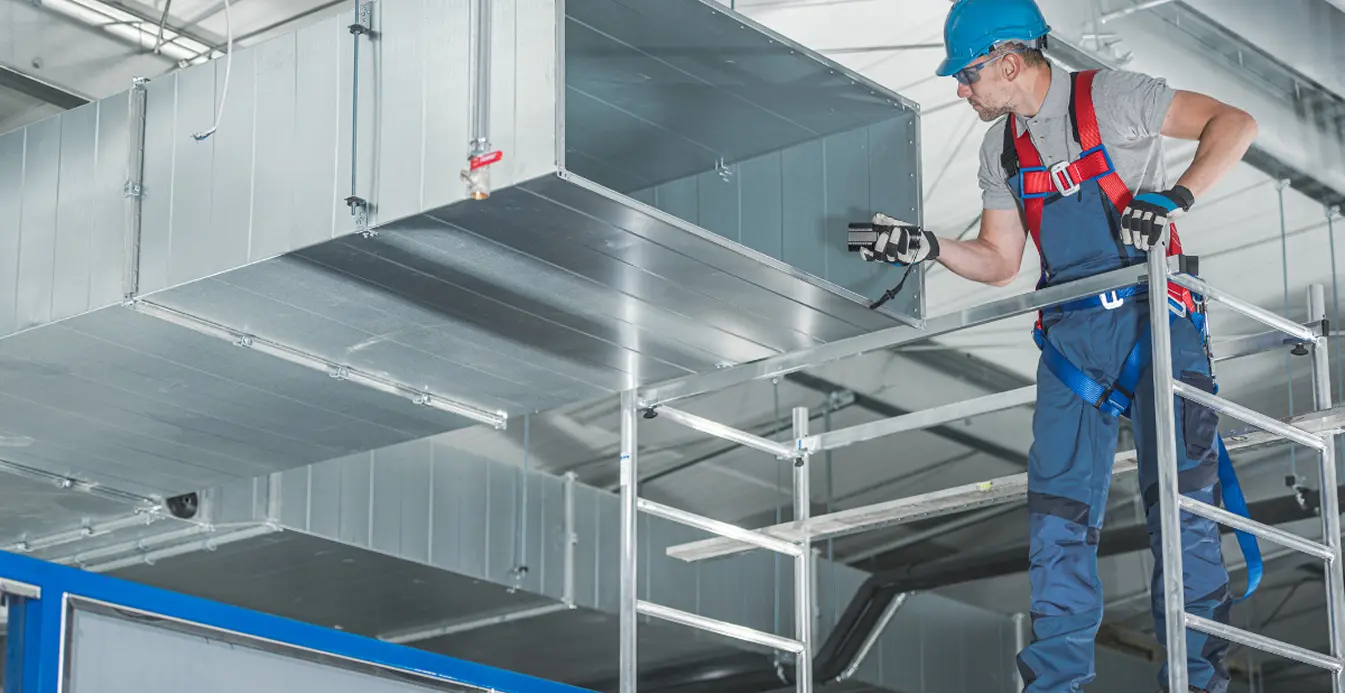Technician inspecting commercial sheet metal ductwork