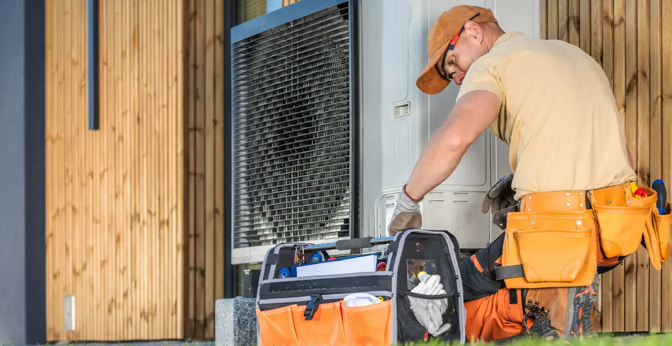 HVAC technician servicing an outdoor air conditioning unit