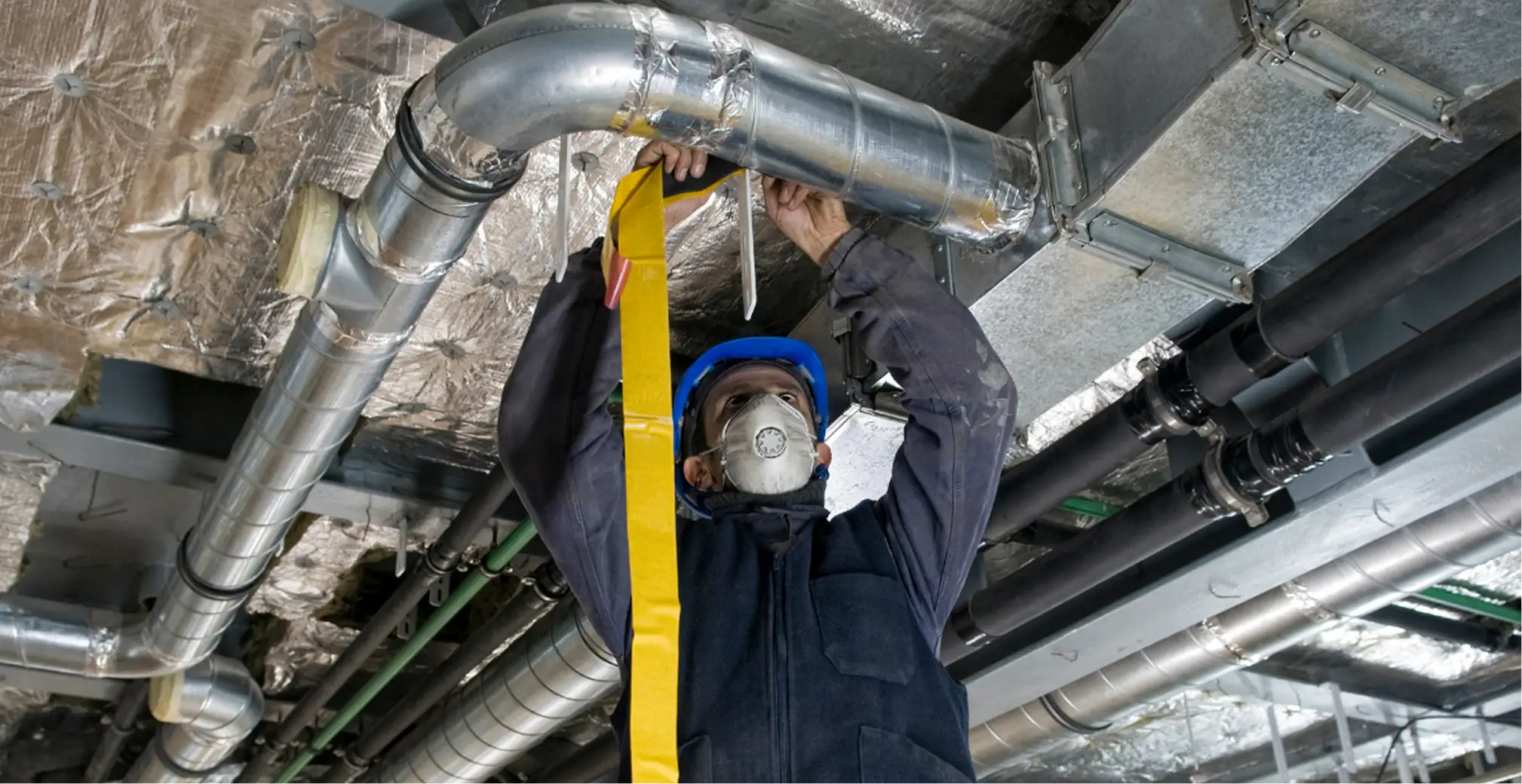 HVAC technician installing sheet metal ductwork