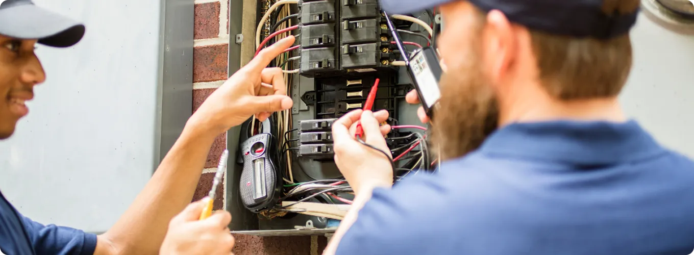 Technician repairing a ceiling-mounted HVAC unit.