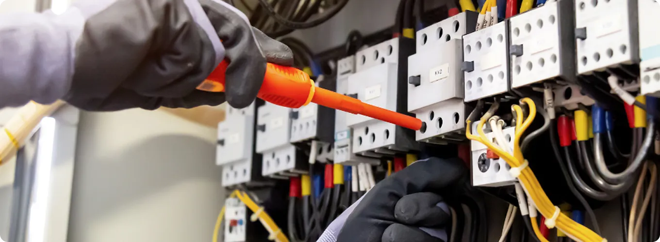 Electrician repairing an electrical panel.