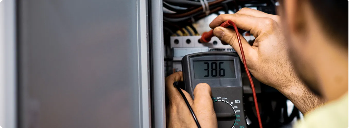Electrician testing voltage with a multimeter.