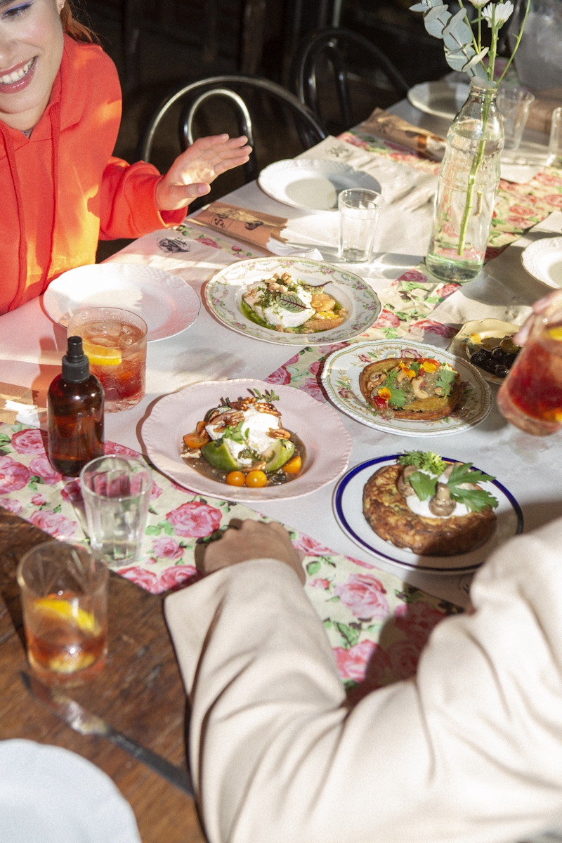 A group of friends sitting at a table eating share plates.