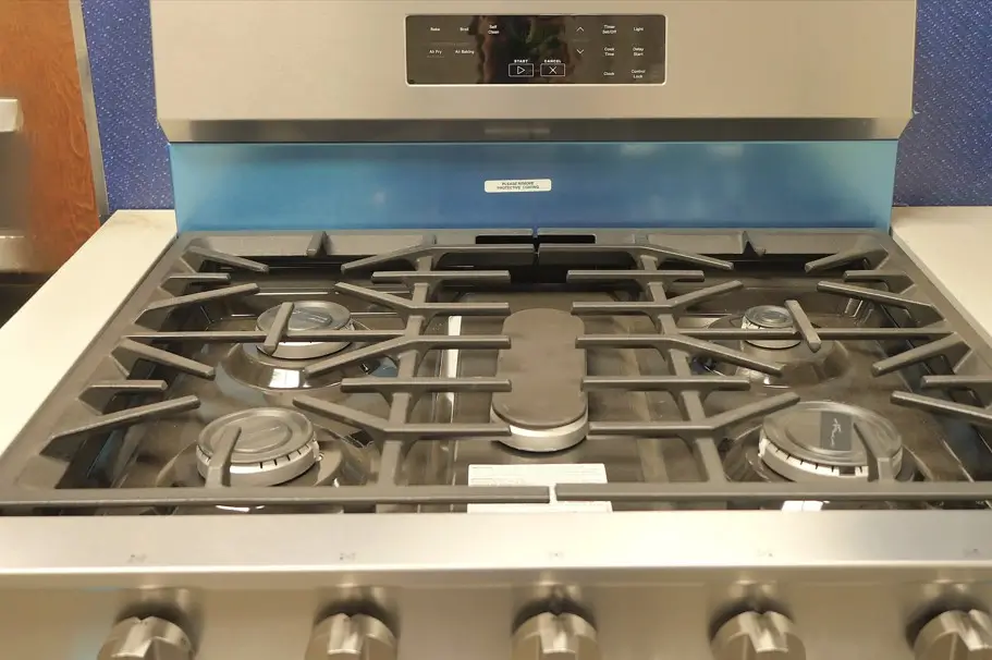 Modern stainless steel gas range with five burners and control knobs at the front.