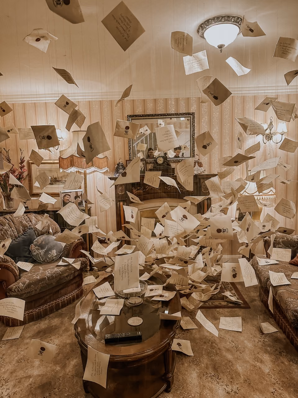 Vintage living room with papers and envelopes floating midair all around a coffee table and sofas.