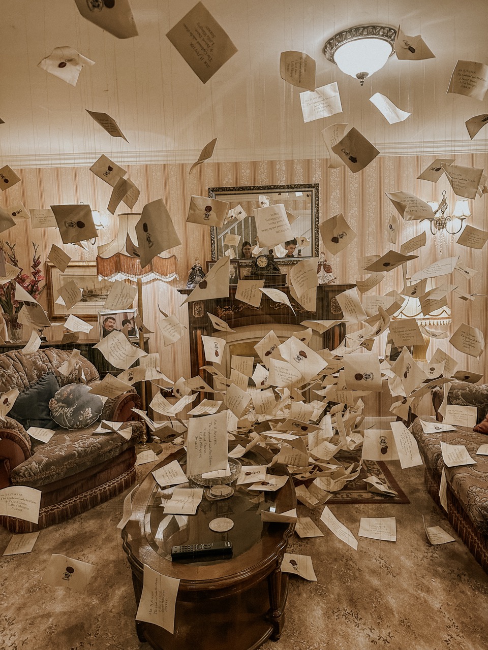 Vintage living room with papers and envelopes floating midair all around a coffee table and sofas.