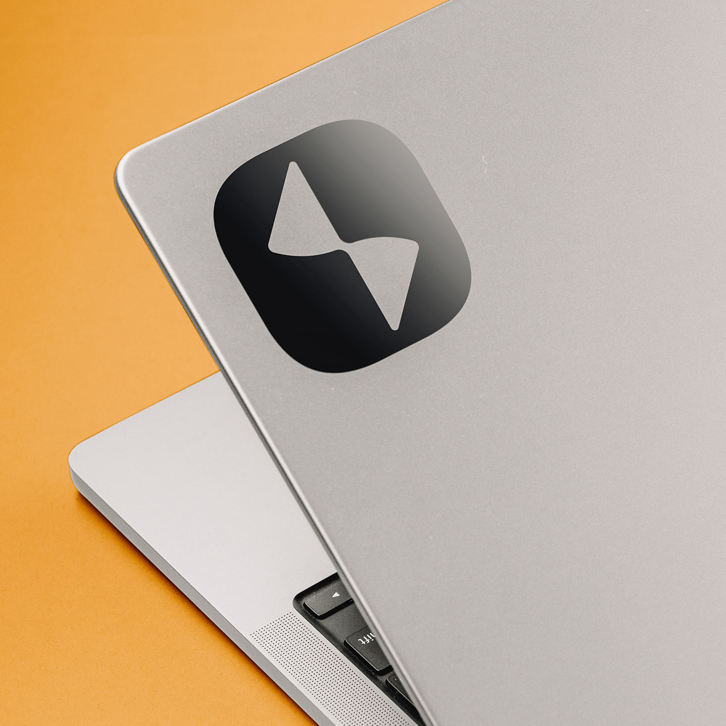 Studio 81 Productions branded laptop sticker mockup showing white logo icon on black vinyl applied to MacBook lid