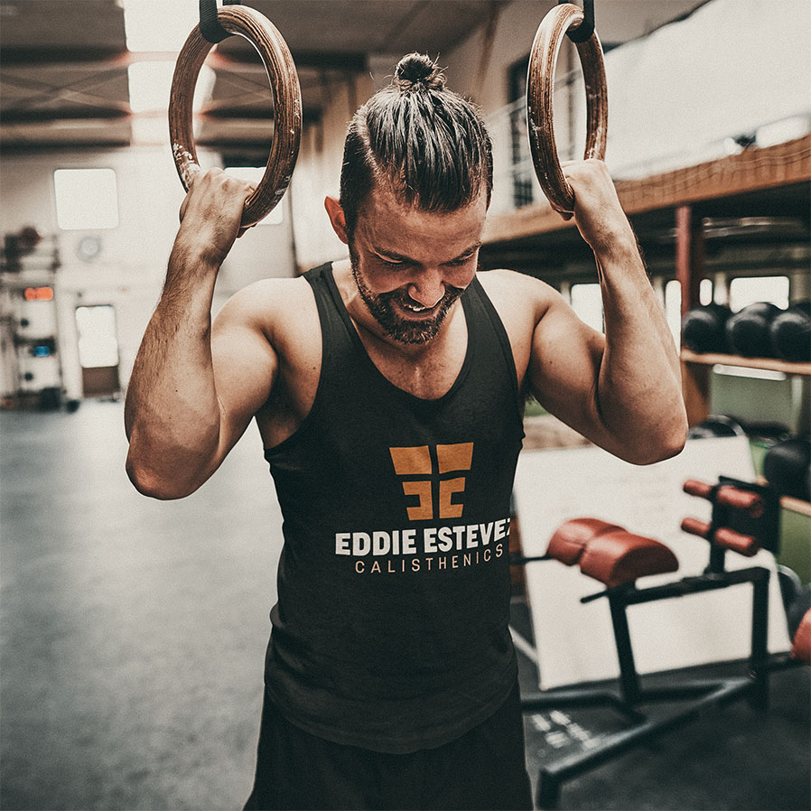 Black workout tank top featuring Eddie Estevez Calisthenics copper and white stacked logo mockup for fitness clothing merchandise