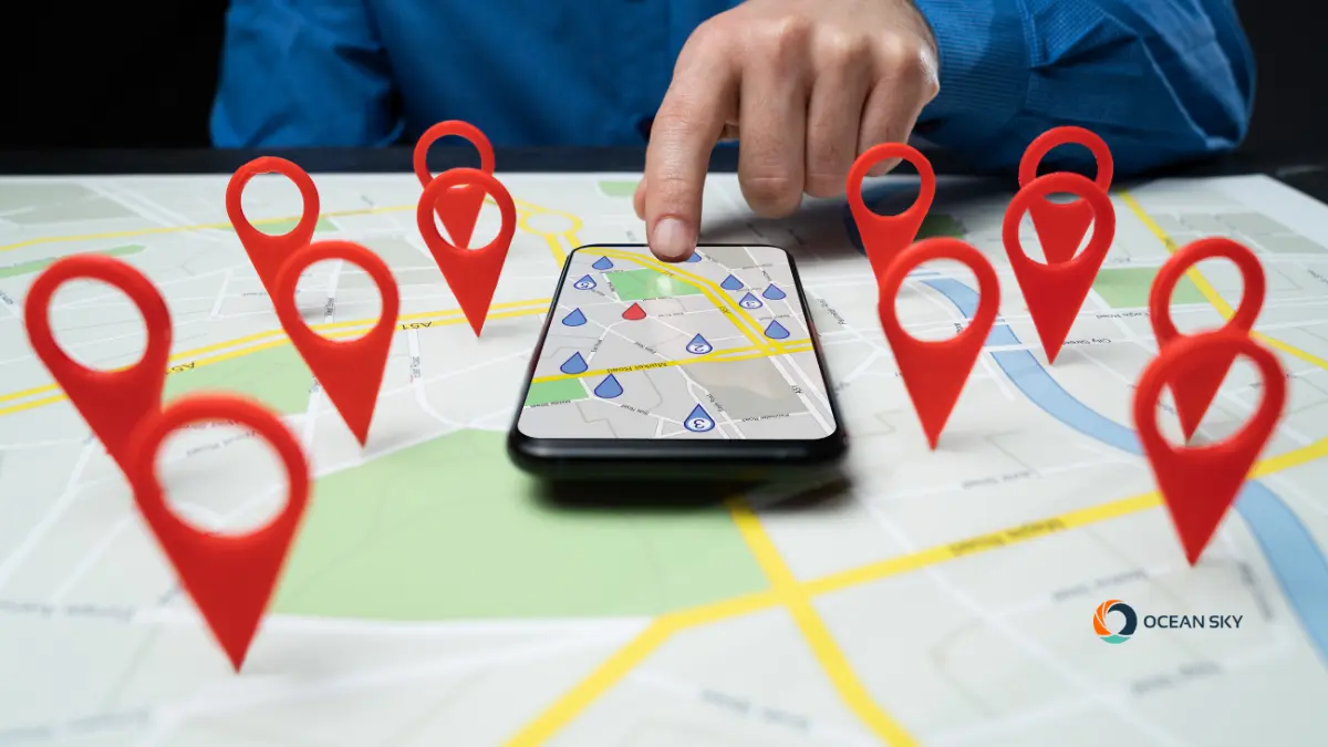 A hand pointing at a map with pins idetifying different locations