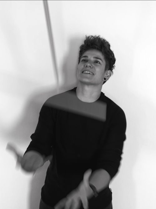 a woman throwing drum sticks in the air.