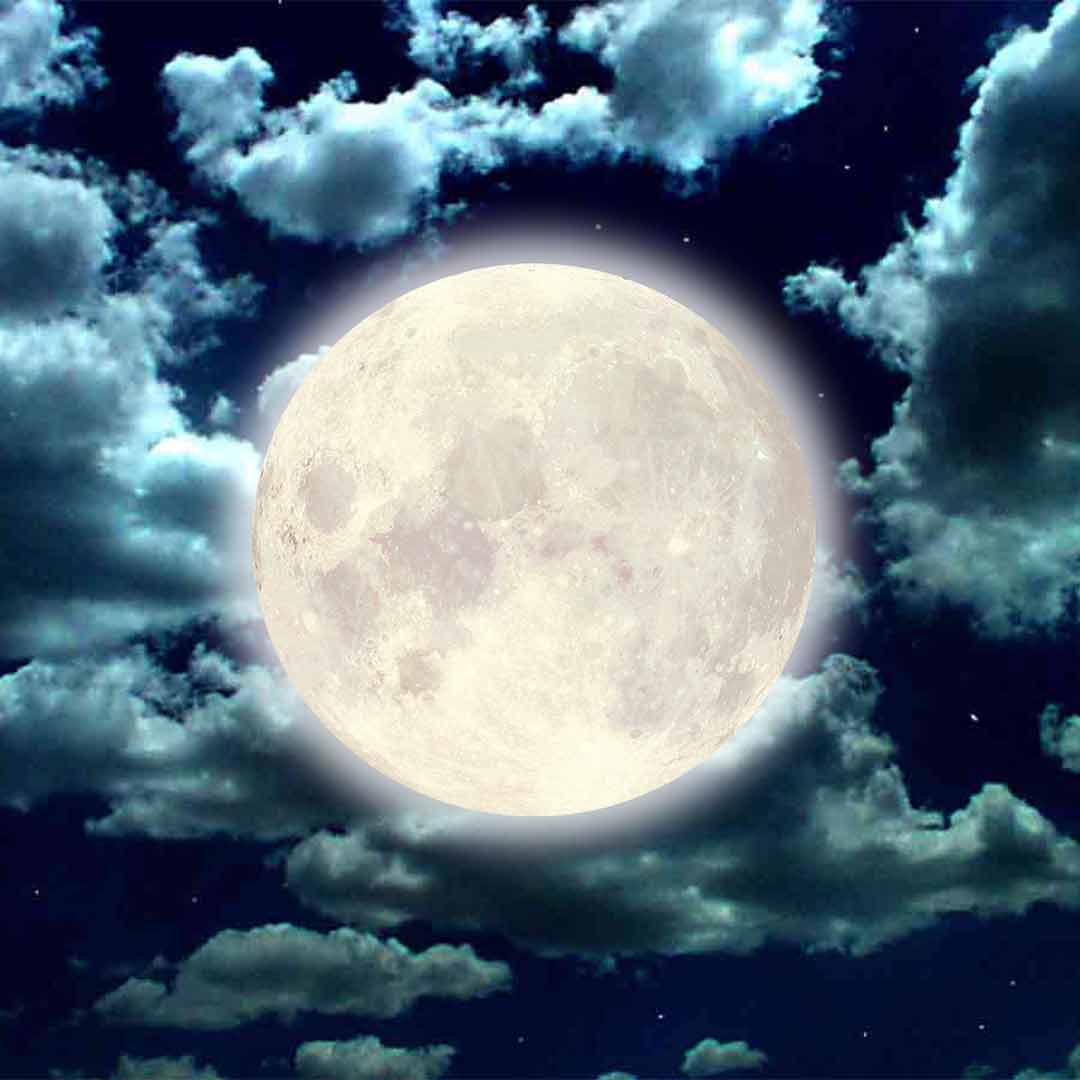 Bright full moon glowing in a dark night sky surrounded by scattered clouds.