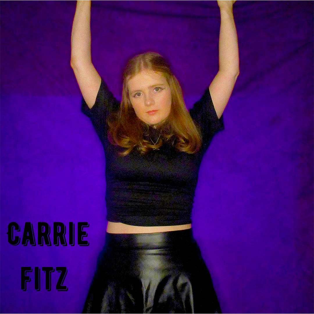 Woman in black top and leather skirt posing with arms raised against purple background.