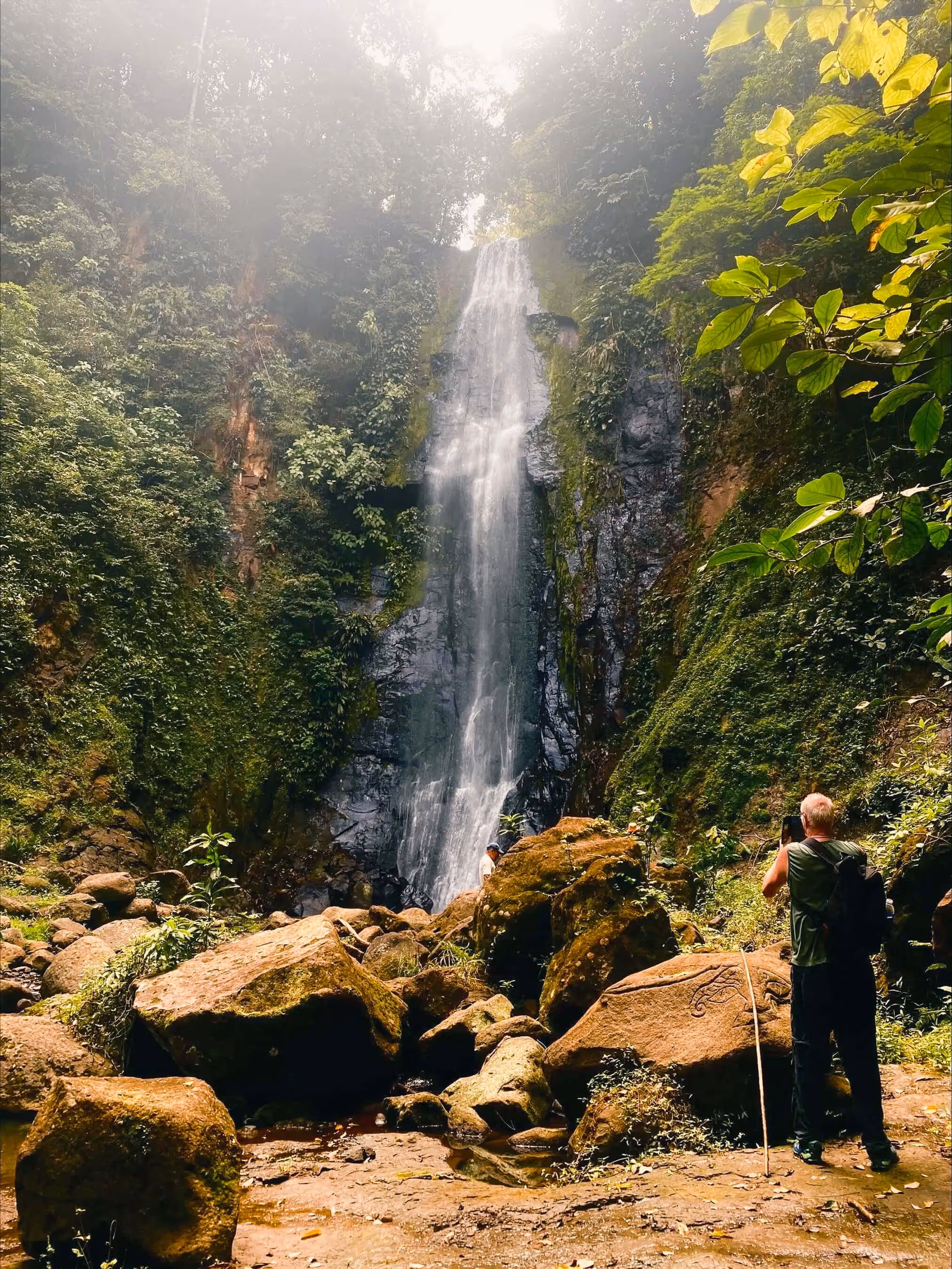 A man enjoying the view of  Kekoldi waterfall in Costa Rica.