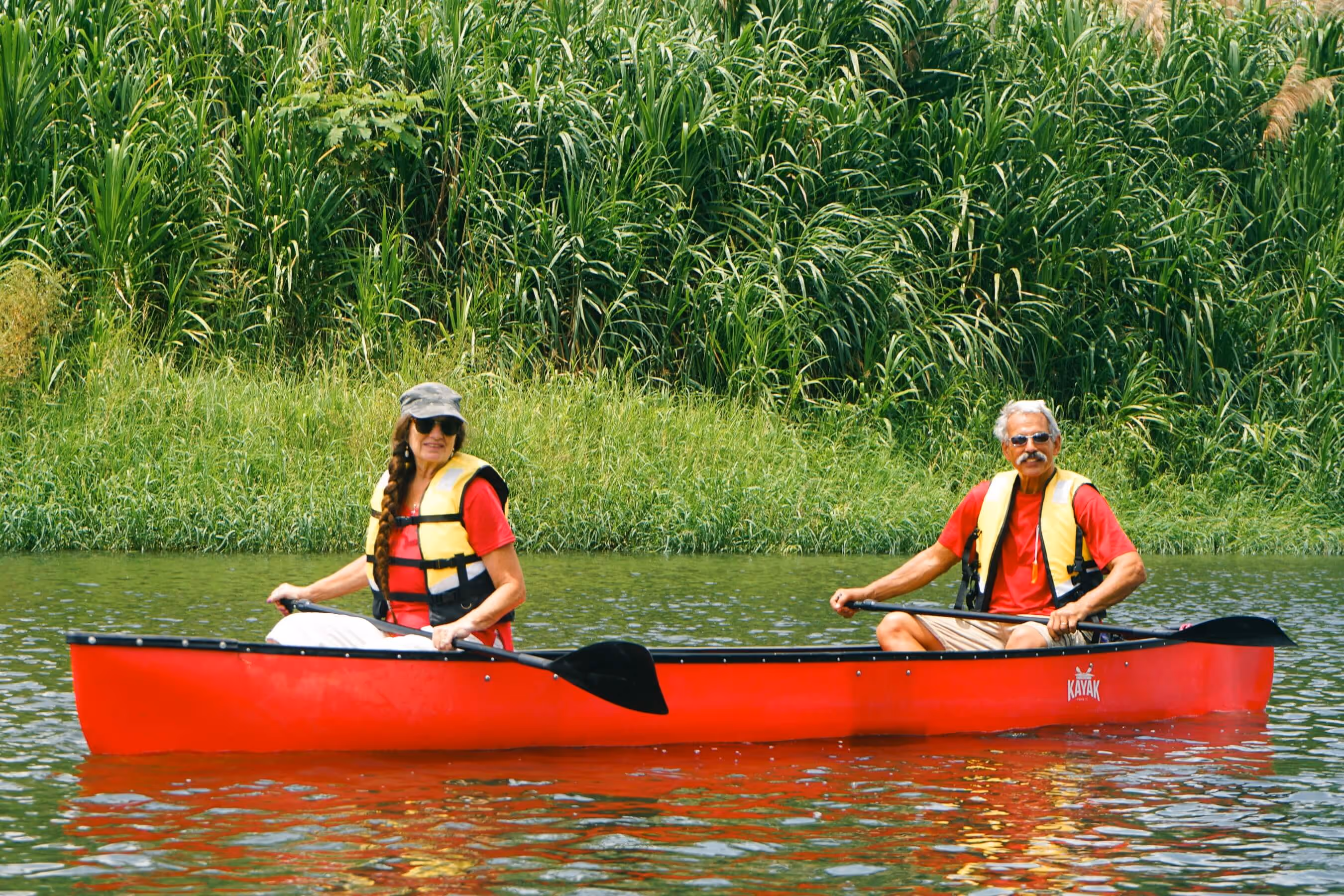 An elderly couple paddling trough silent water in Costa Rica.