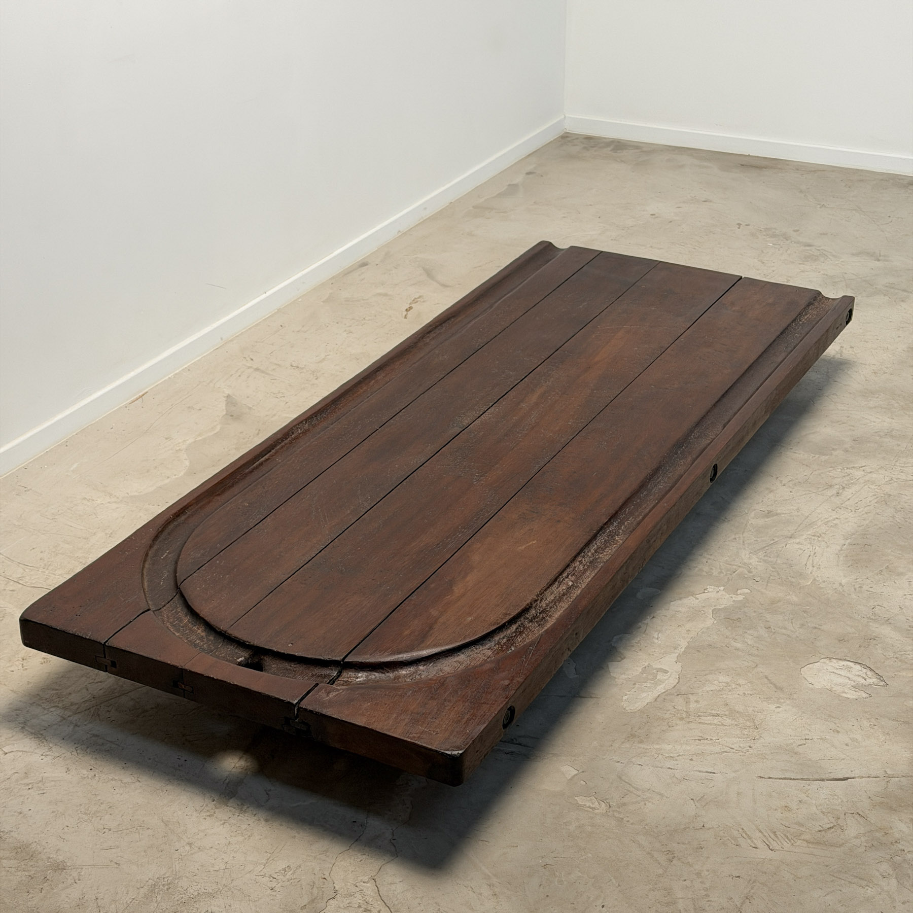 Low coffee table made from an early 20th-century cheesemonger’s board