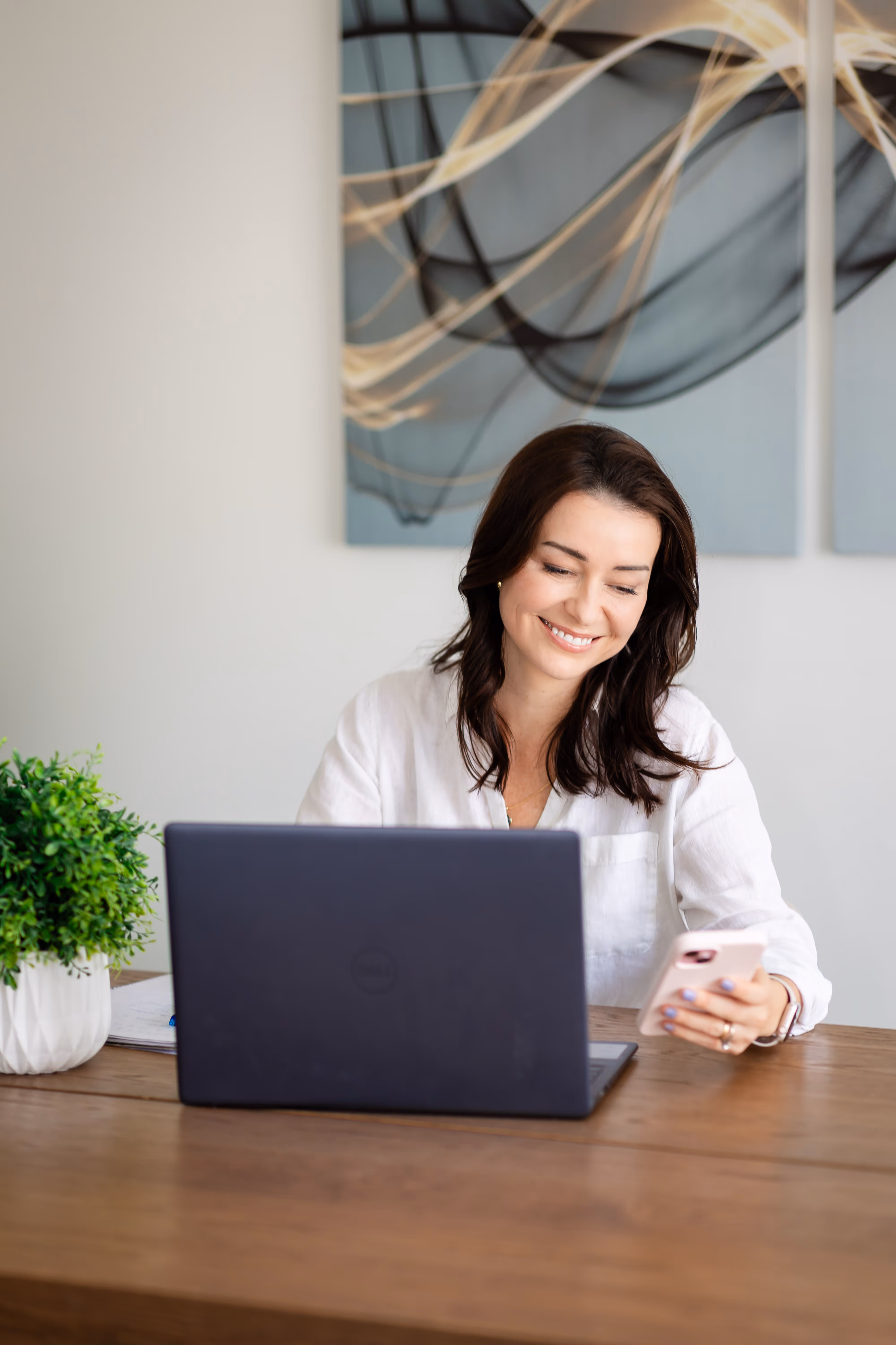 Camila Drehmer, founder of LogicaTalent, smiling while conducting a virtual coaching session from her laptop, symbolizing confidential and personalized online support.