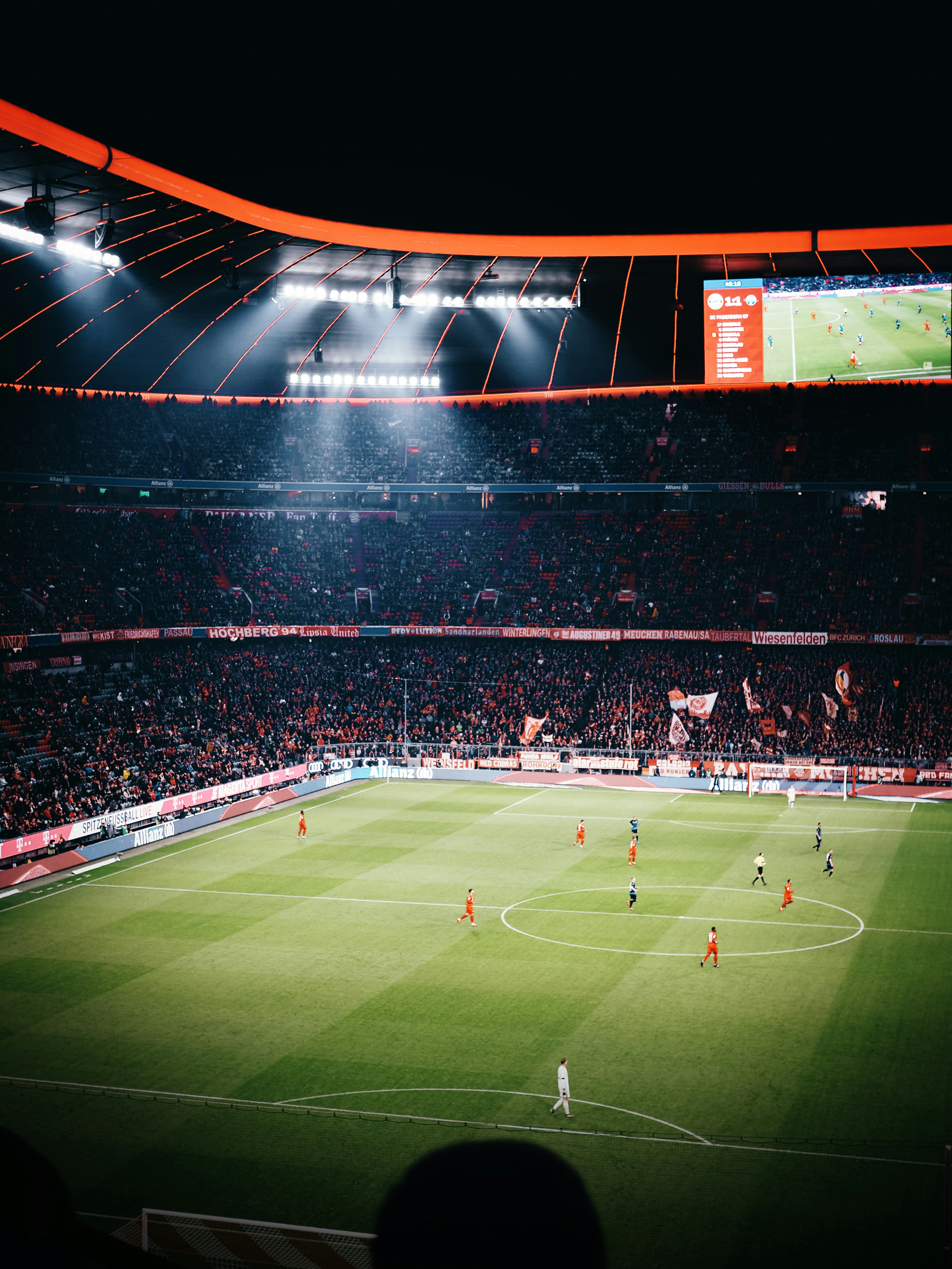 A football stadium in the night time during a game.