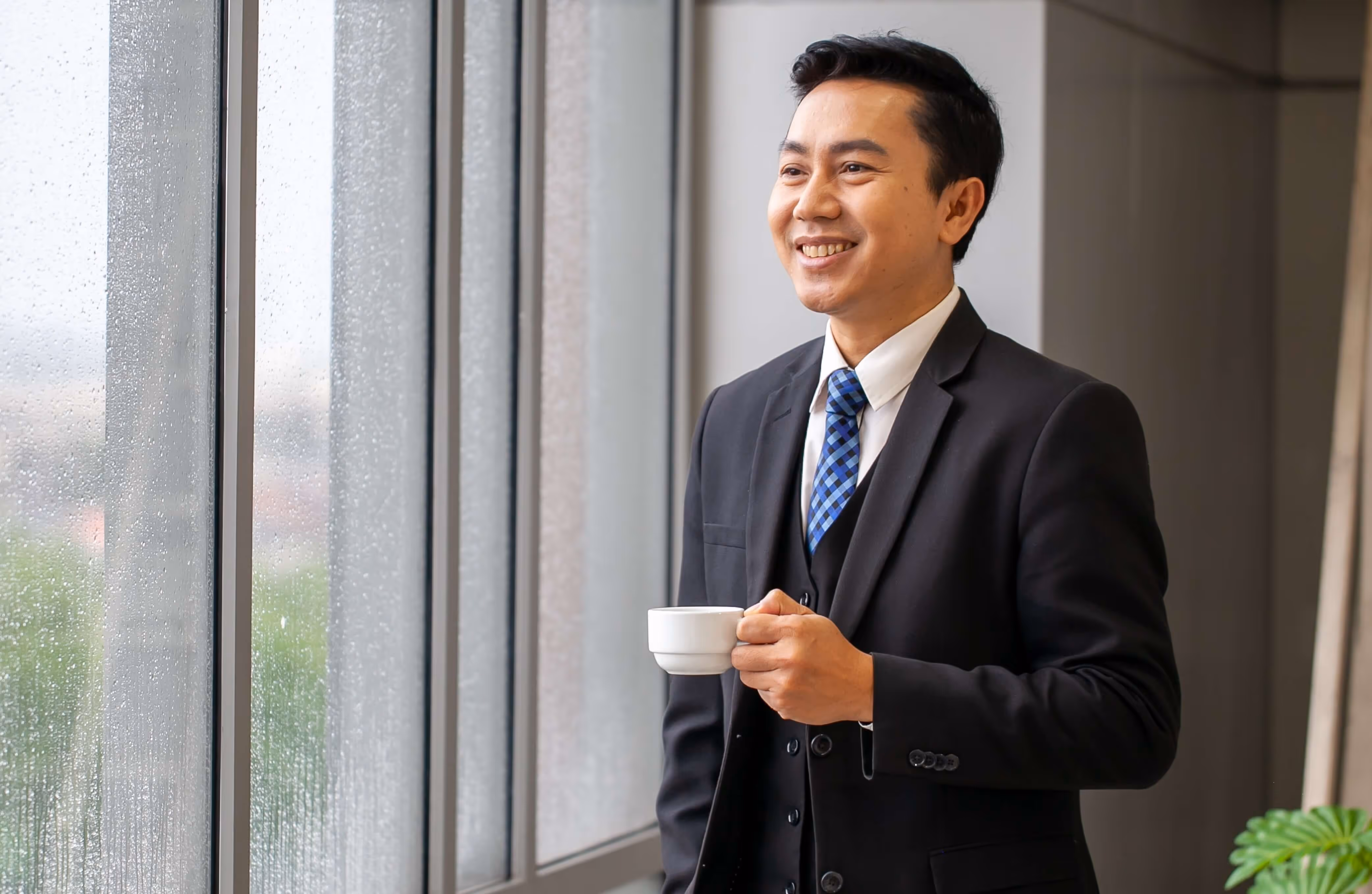 A man in a suit and tie holding a cup.