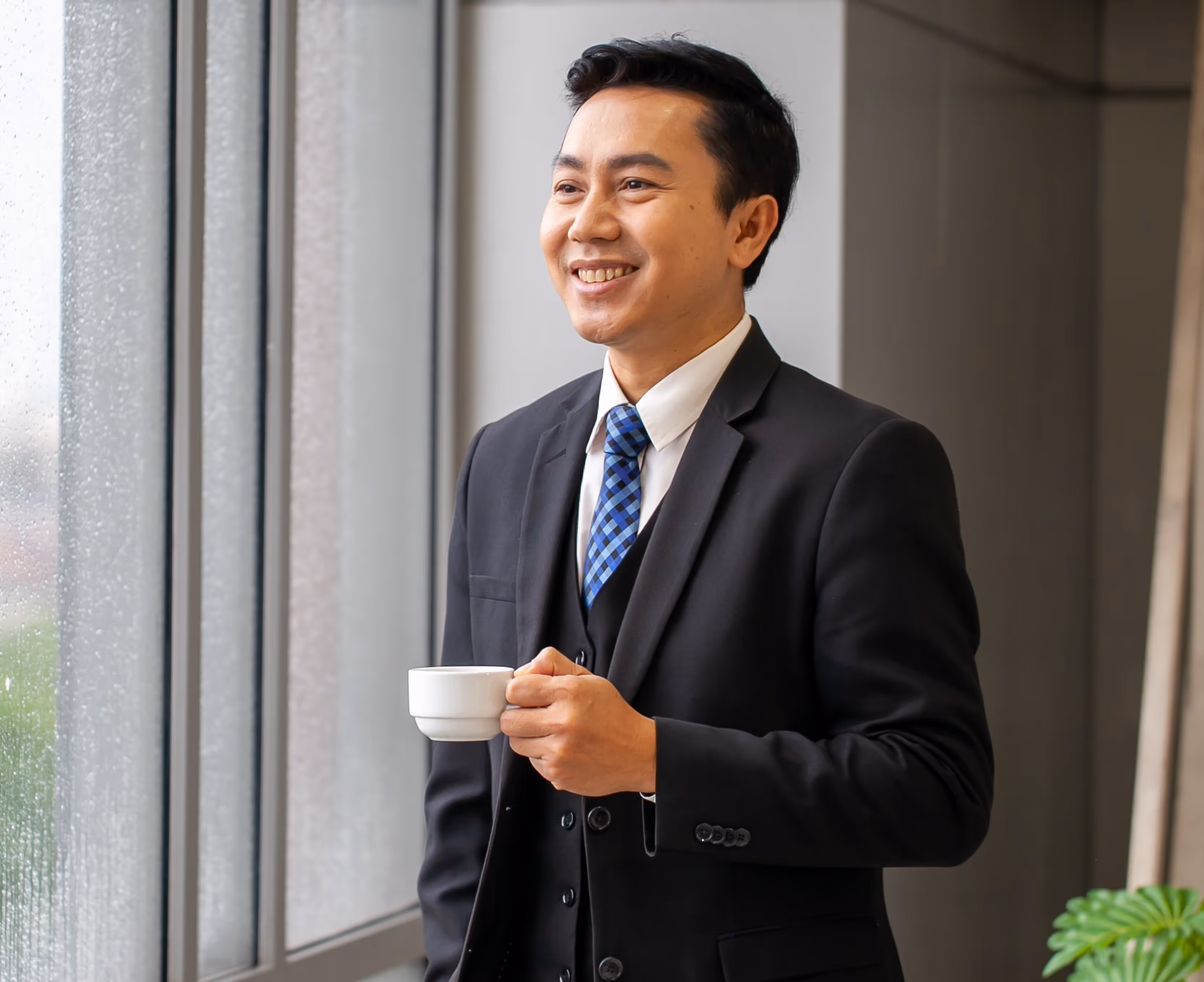 A man in a suit and tie holding a cup.
