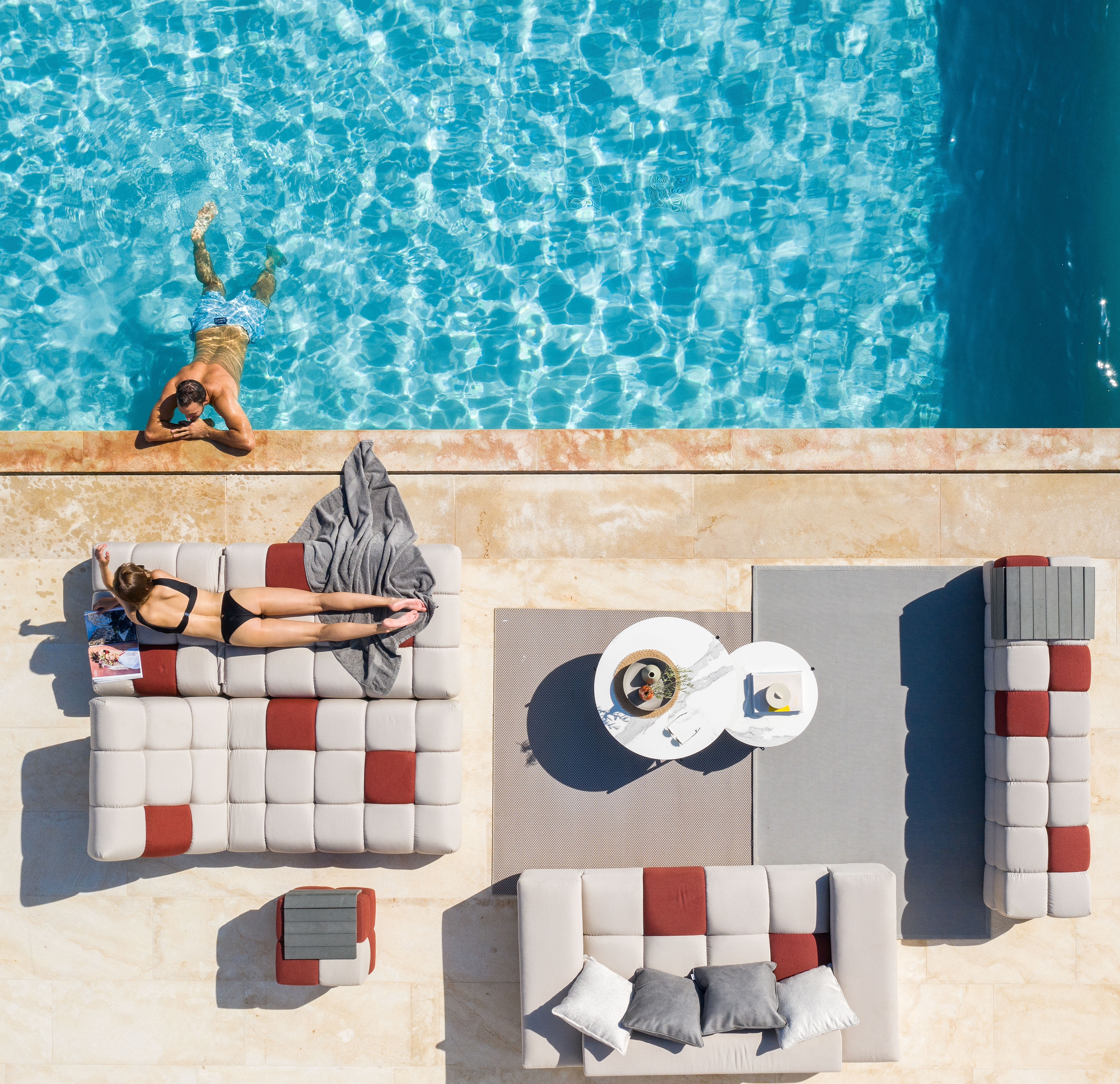Zona lounge de lujo al aire libre junto a una piscina, con sofás y tumbonas, vista aérea en una villa mediterránea — Secret Garden Marbella.
